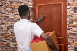 Delivery person handing over a parcel at the front door