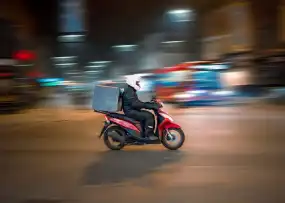 Motorcycle courier riding through Nairobi streets for fast delivery